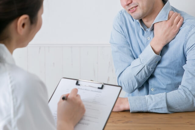 肩の痛みを医師に伝える男性