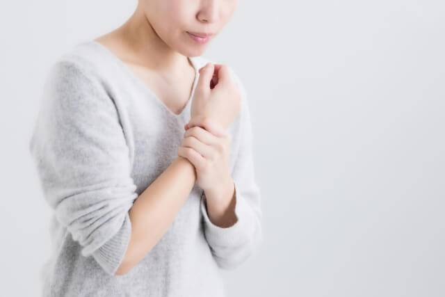 手首を押さえる女性