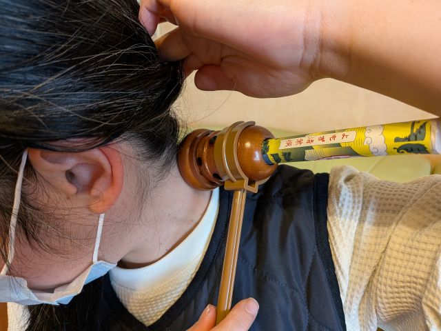 器具を使った棒灸で首を温めている所